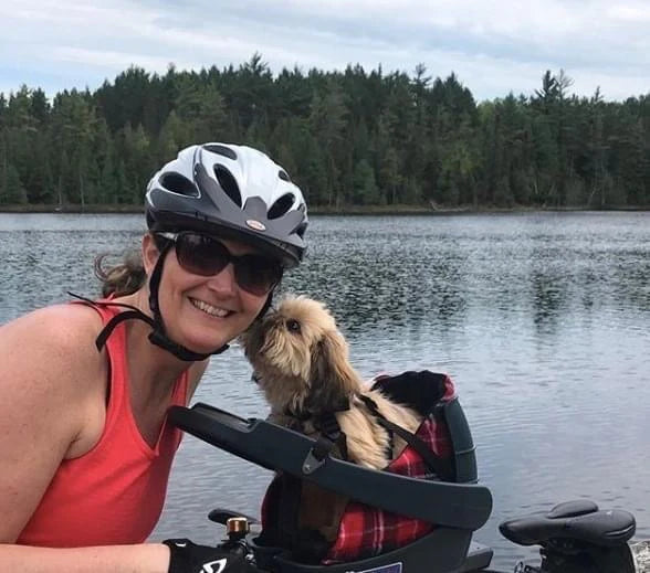 Small dog giving mom a kiss for taking her cycling in the Buddyrider bike dog carrier